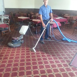 Employé nettoyant un tapis commercial